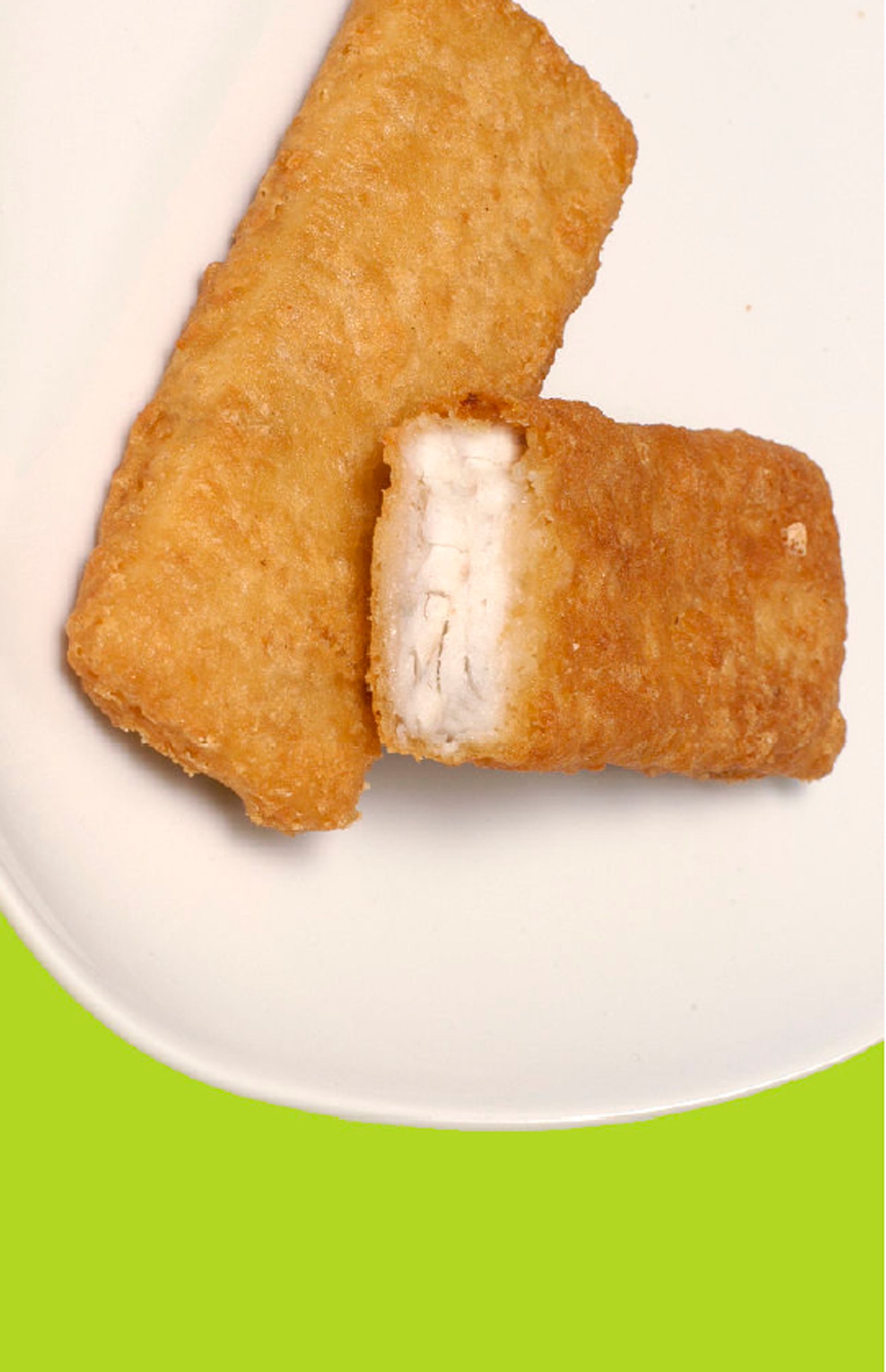 Two fried fish sticks on a white plate with a bite taken out of one