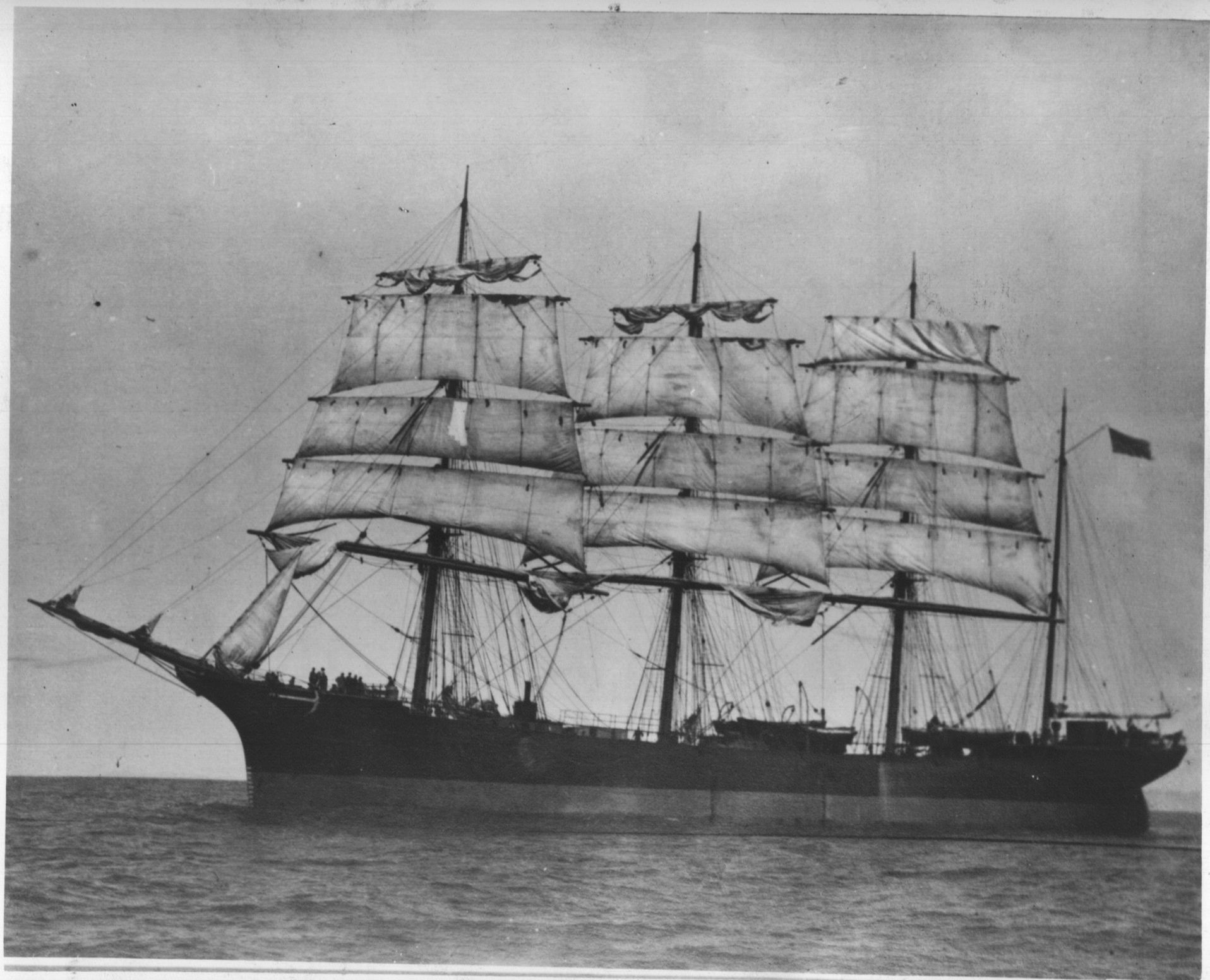 A black and white photo of a sailboat in the ocean