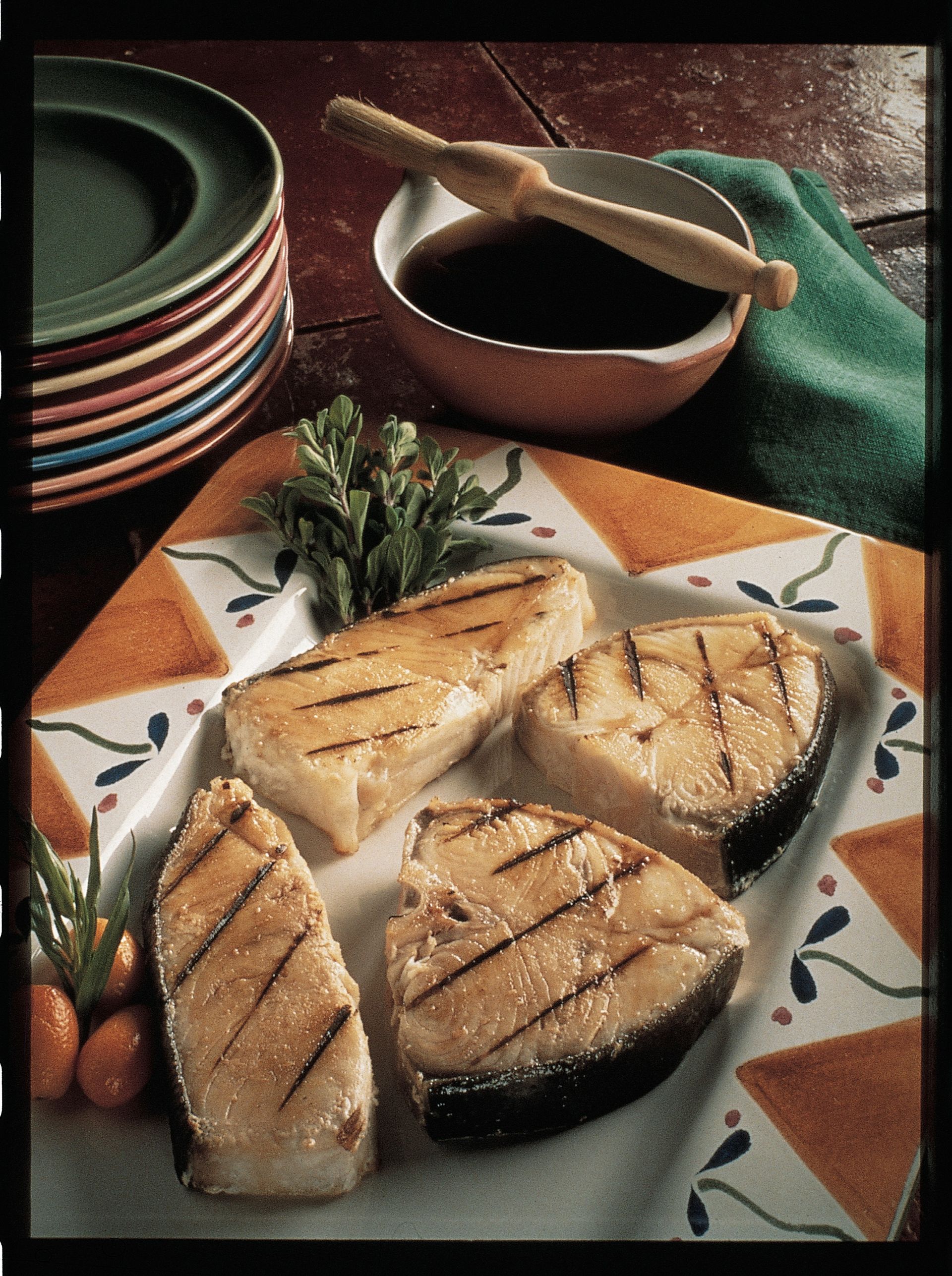 A plate of grilled fish with a bowl of dipping sauce