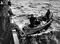 A group of men are rowing a boat in the ocean.