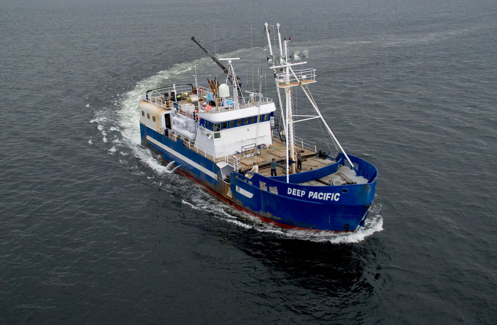 A large blue and white ship is floating on top of a body of water.