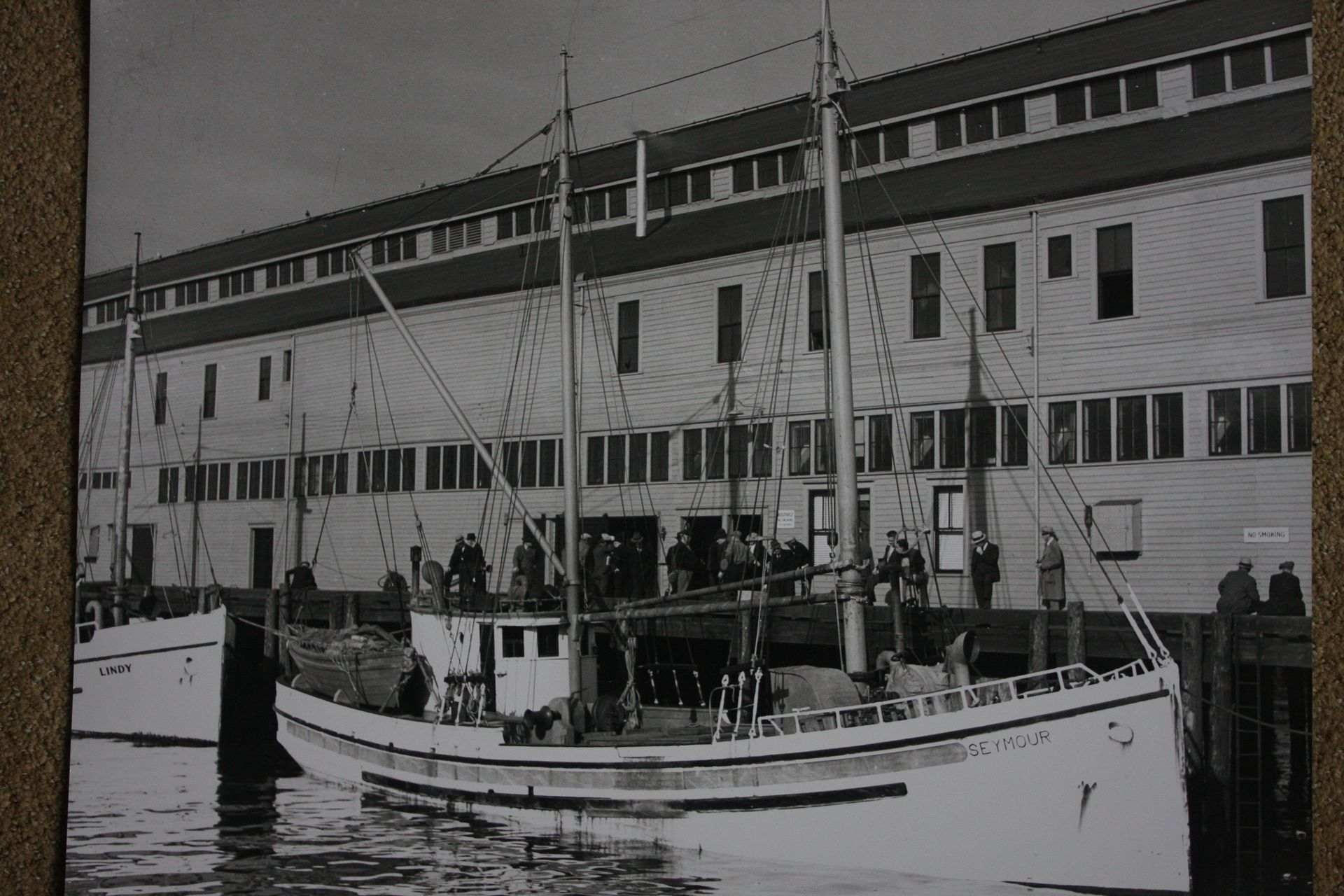 A black and white photo of a boat in front of a building