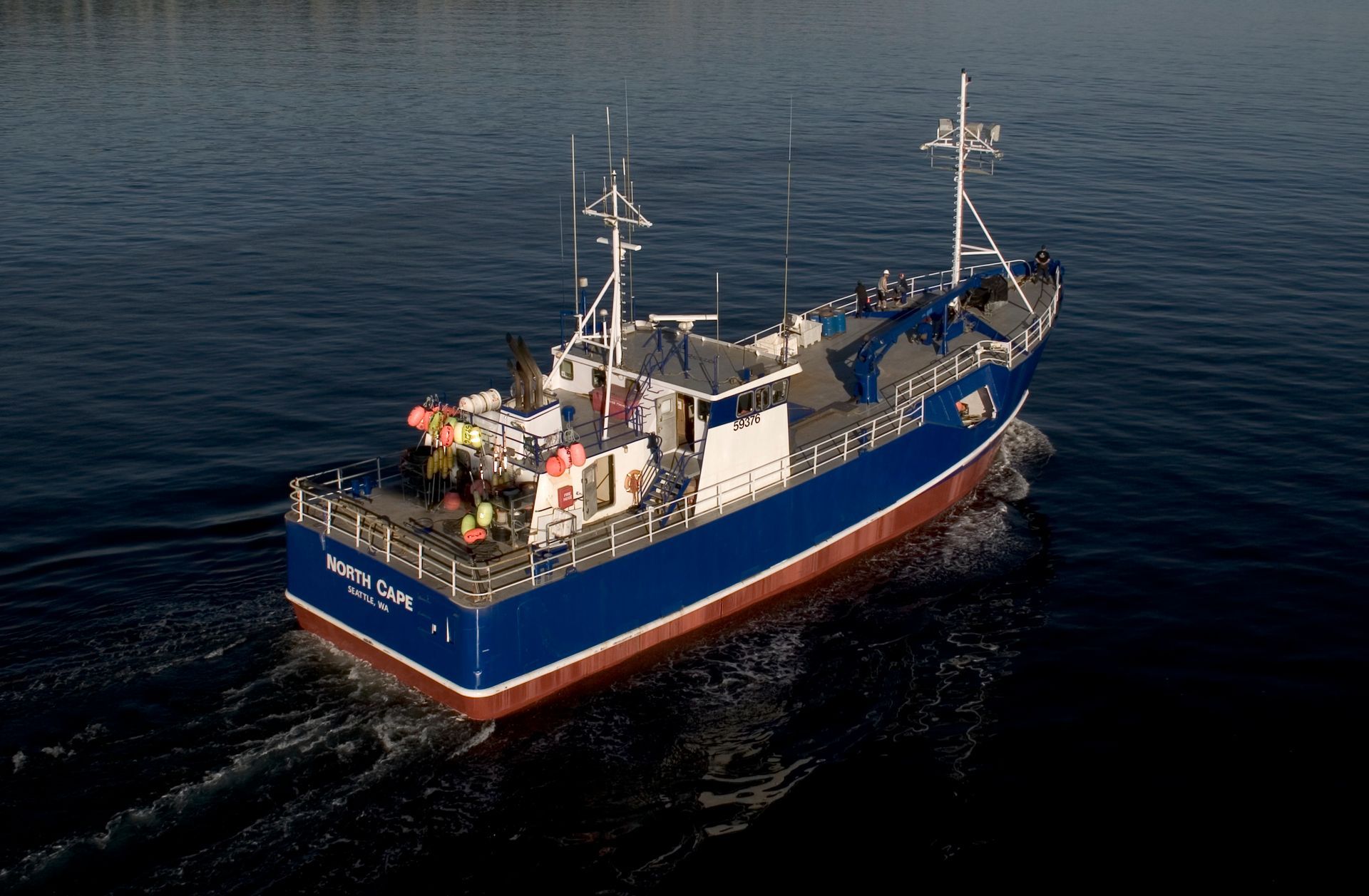 A large blue ship is floating on top of a body of water