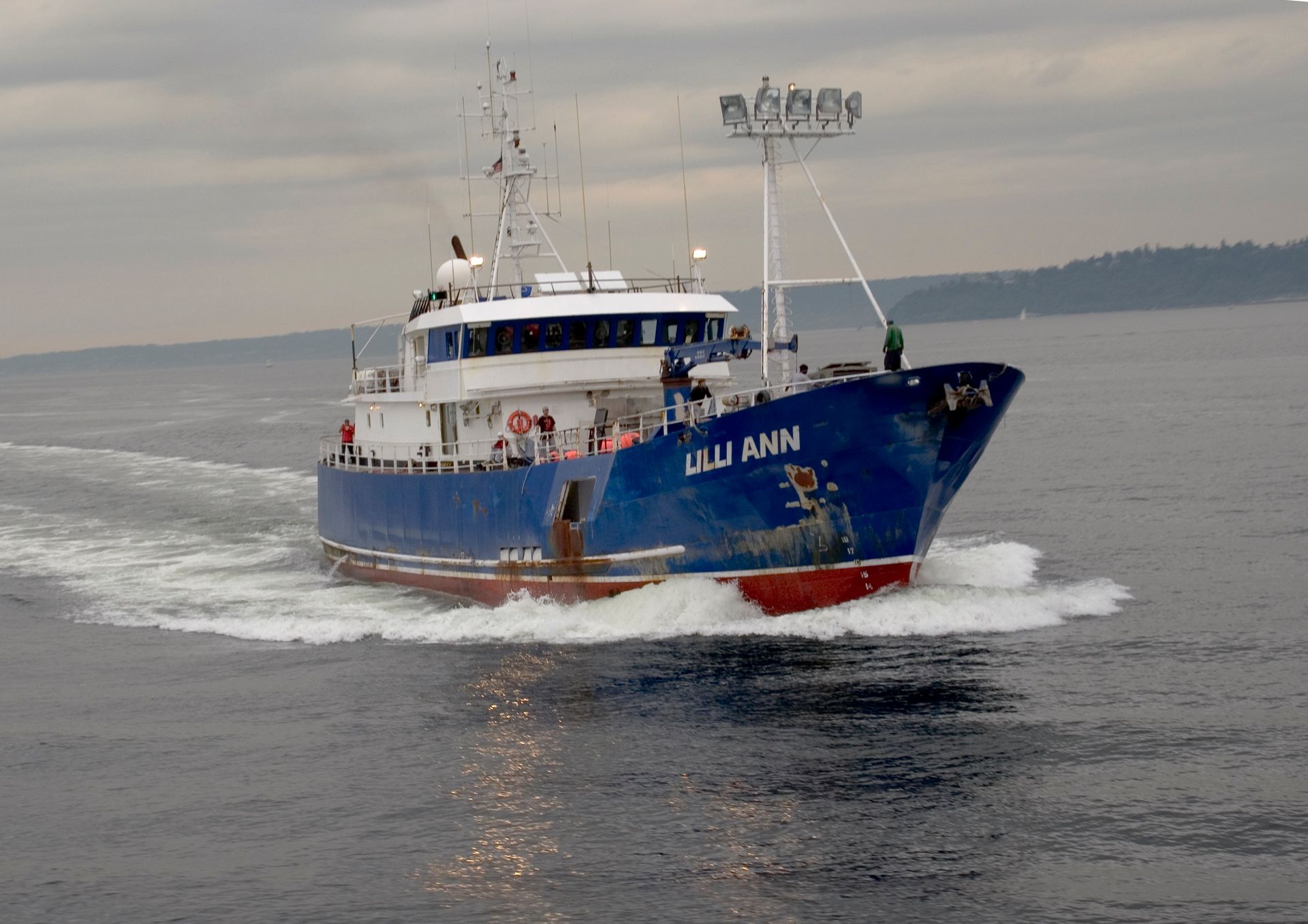 A large blue and white boat is floating on top of a body of water.
