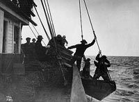 A group of men are standing on a boat in the ocean.