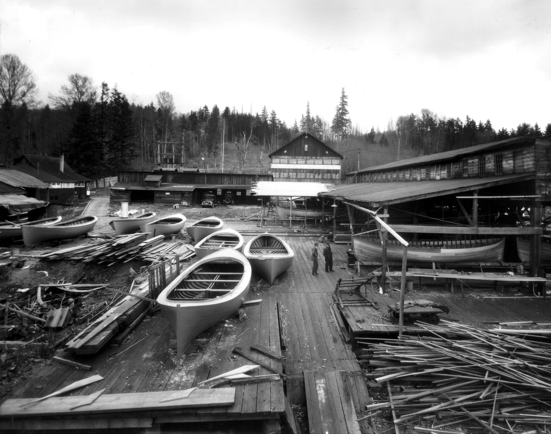 A black and white photo of a canoe factory