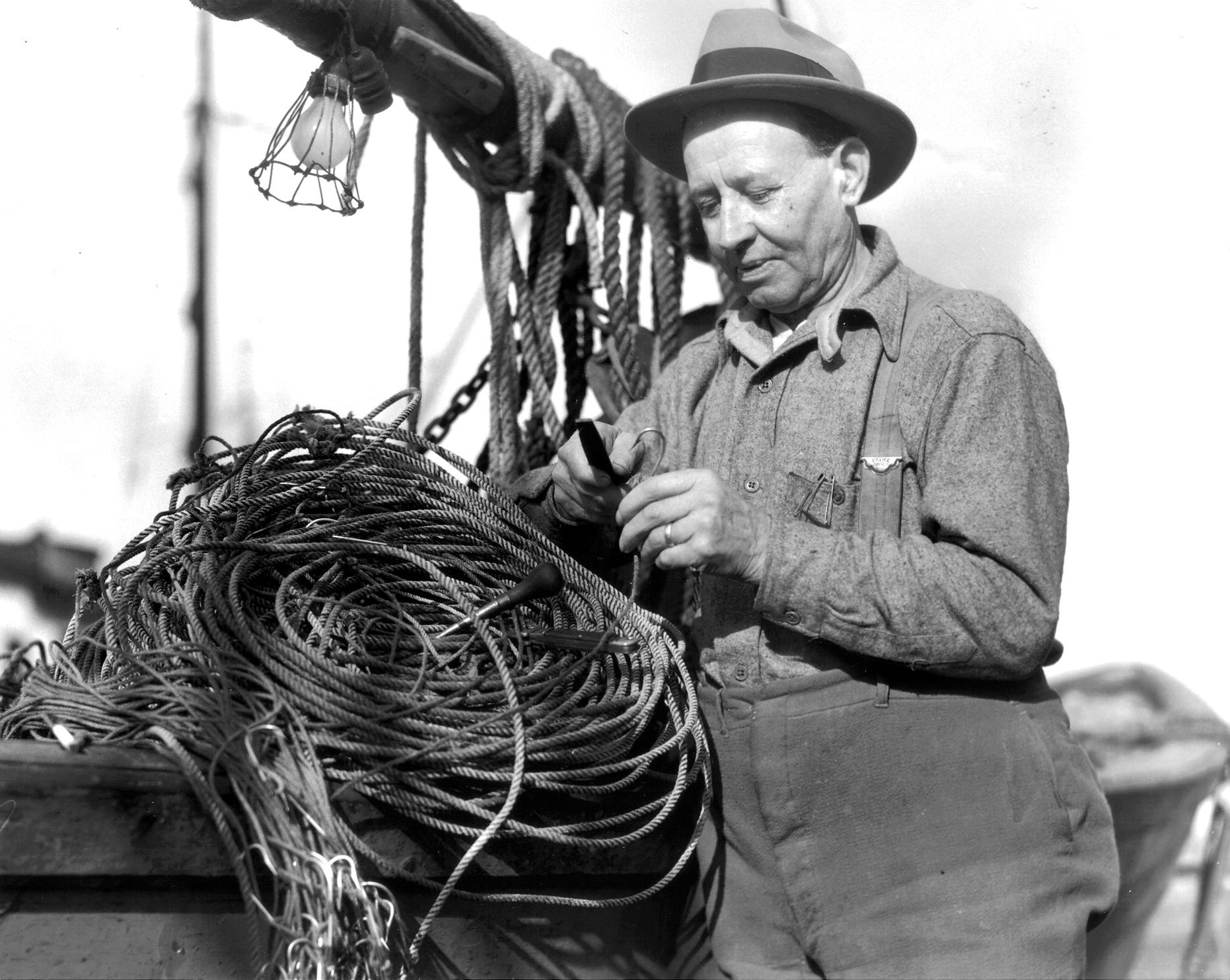 A man in a hat is working on a bunch of wires