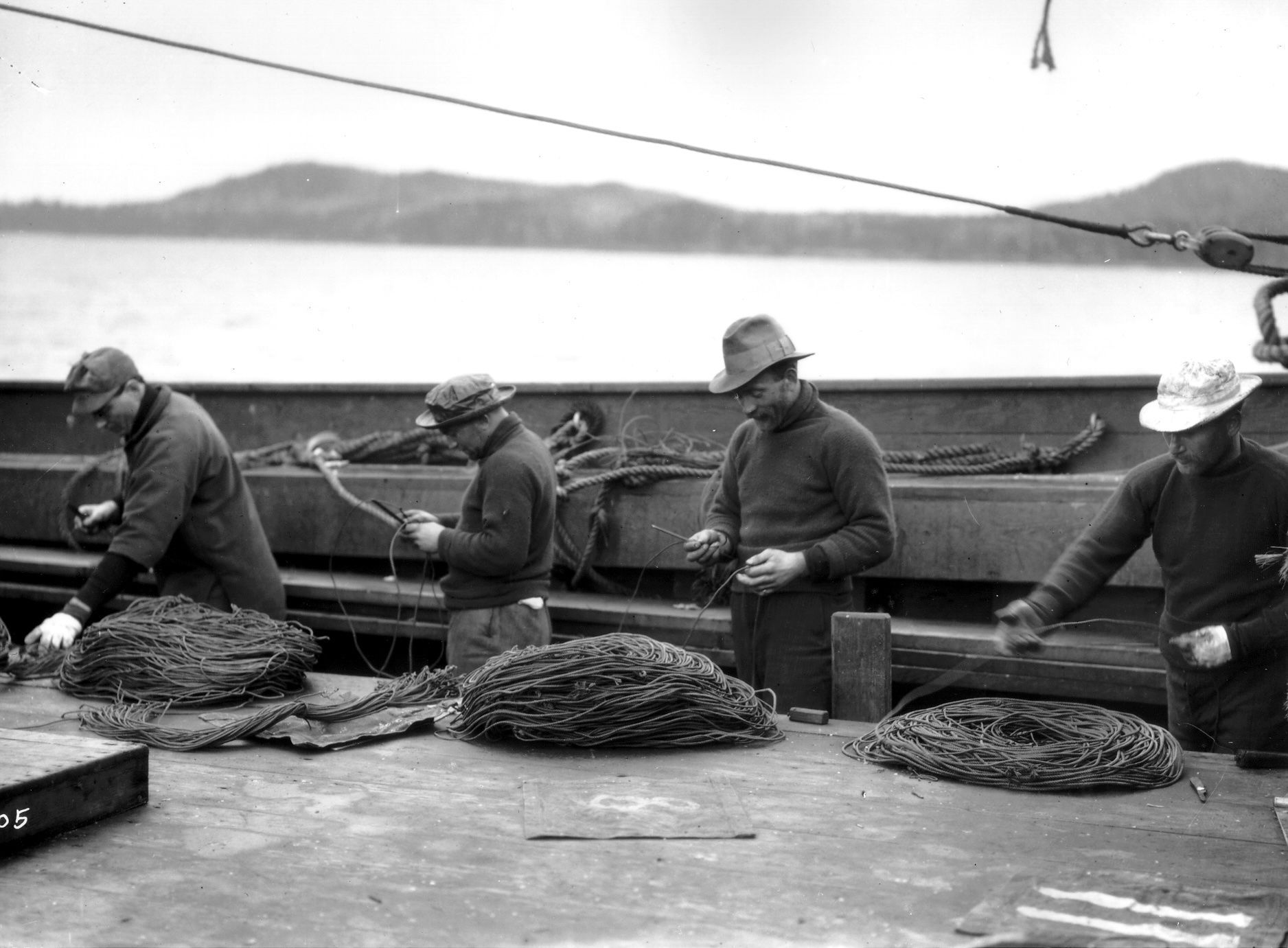 A group of men are working on a boat in the water.