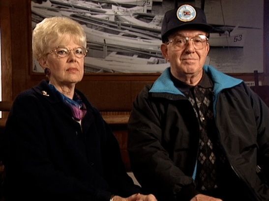 A man and a woman are sitting next to each other and holding hands