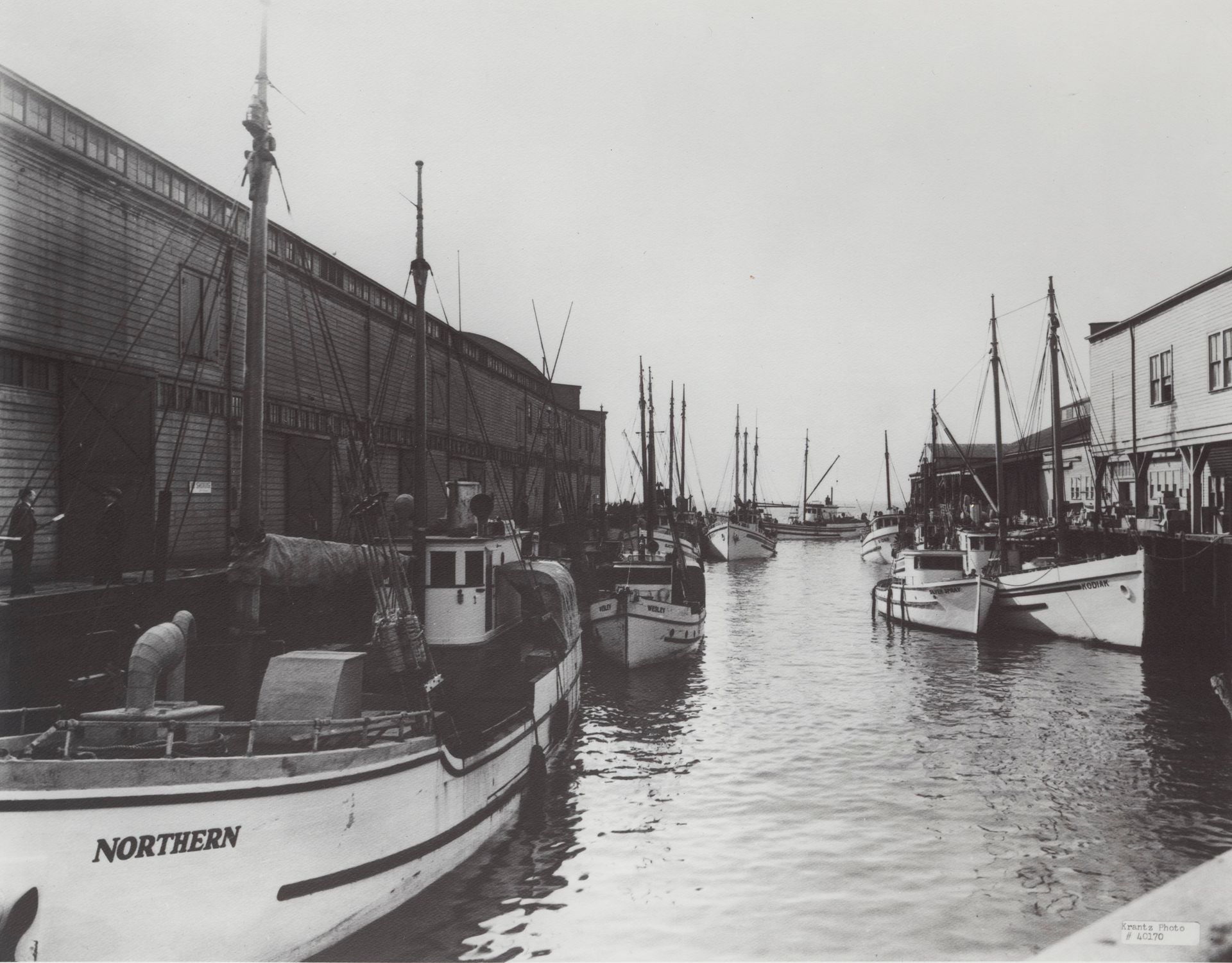 A black and white photo of northern boats in a harbor