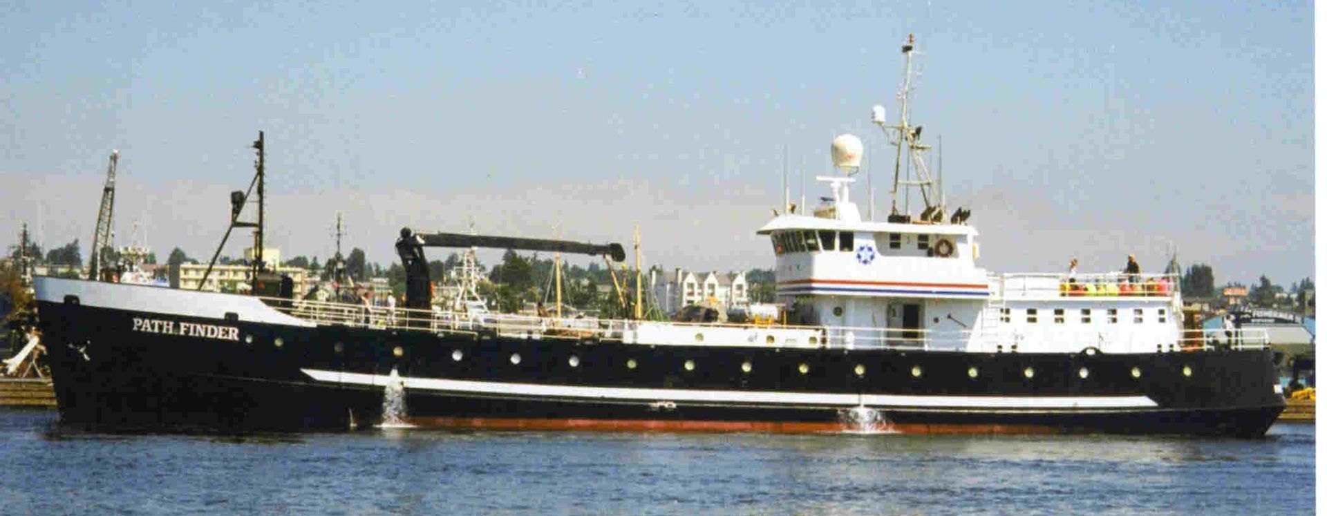 A large black and white ship is floating on top of a body of water