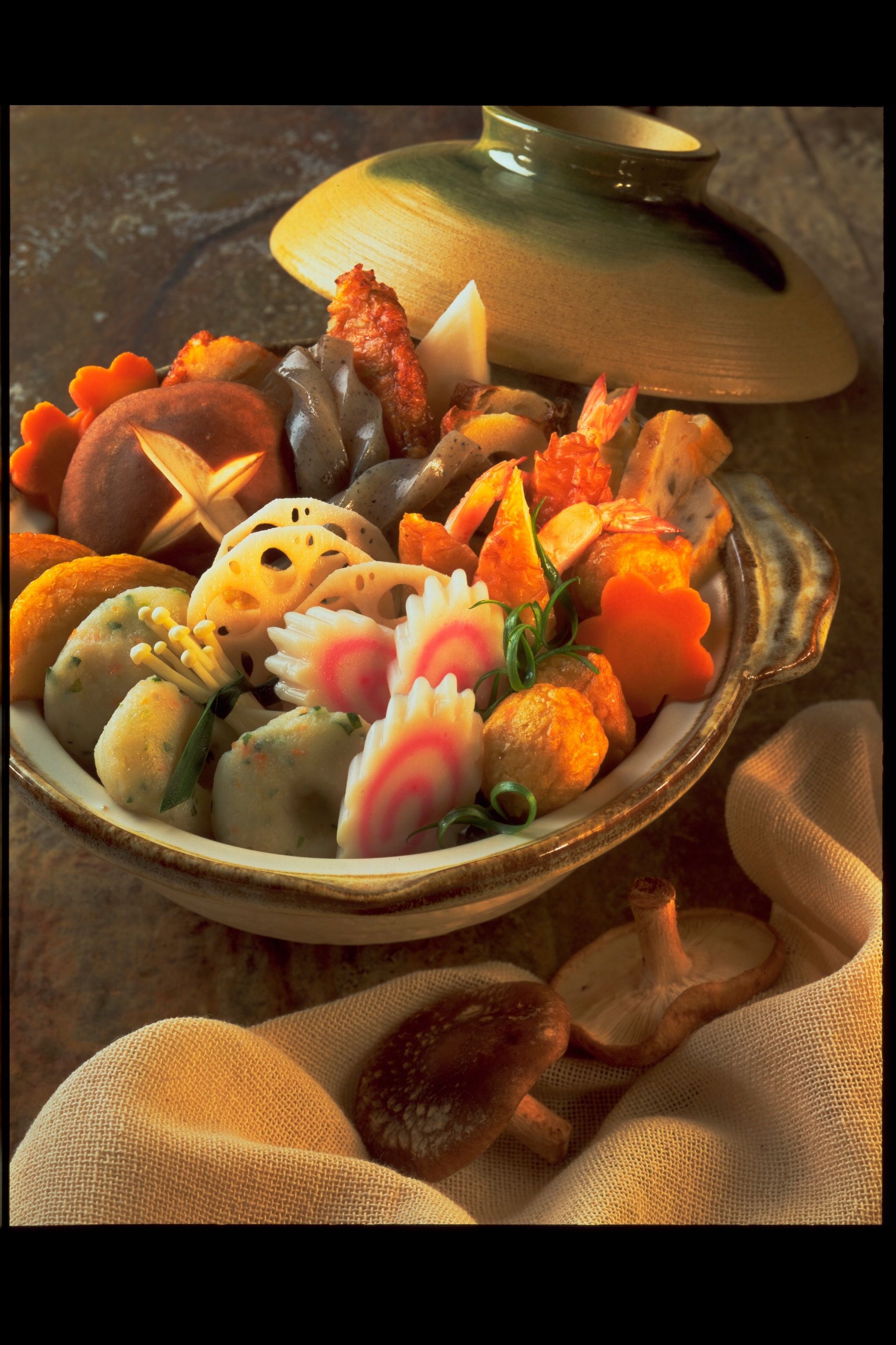 A bowl of vegetables is sitting on a table next to a pot.