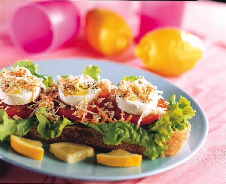 A plate of food with eggs tomatoes and lettuce on a table