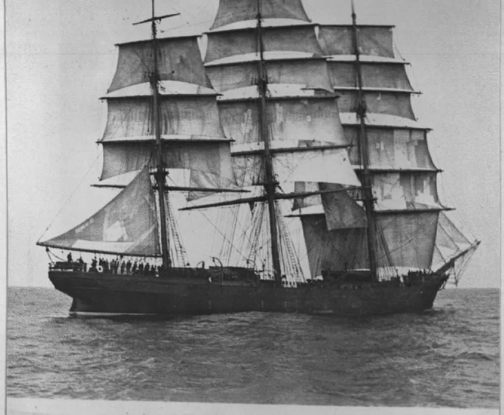 A black and white photo of a sailboat in the ocean