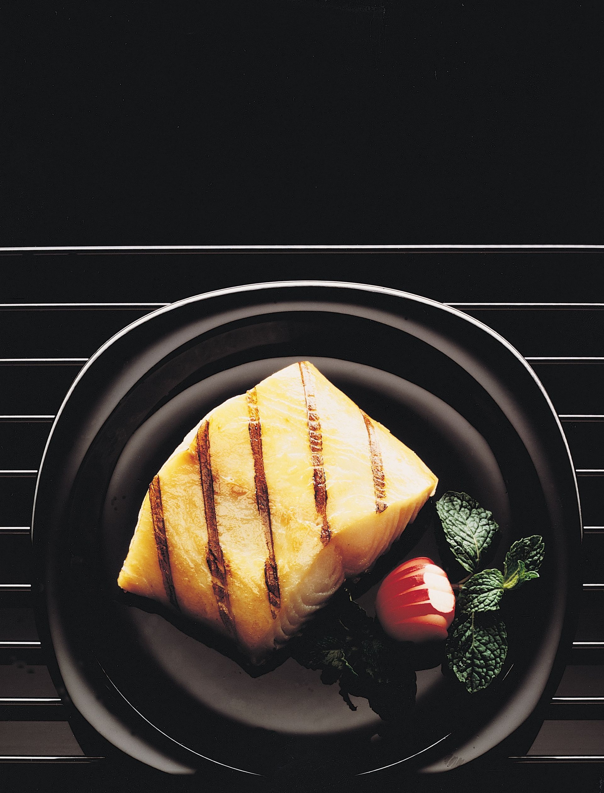 A black plate with a piece of food on it