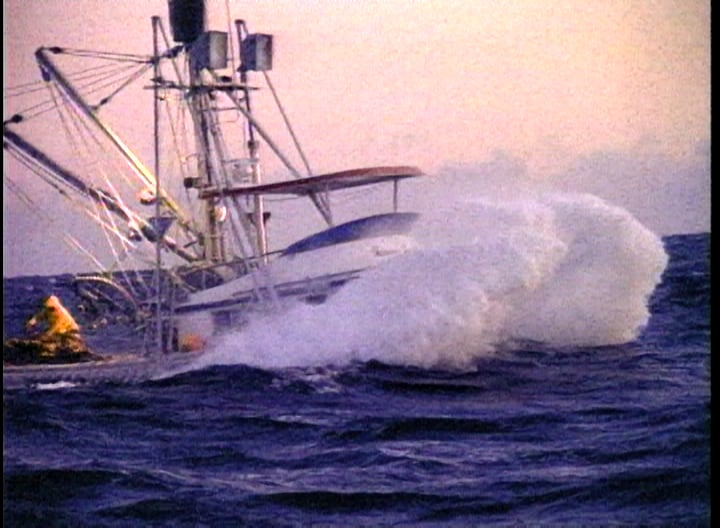 A boat in the ocean with smoke coming out of it