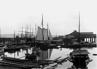 A black and white photo of boats docked in a harbor.