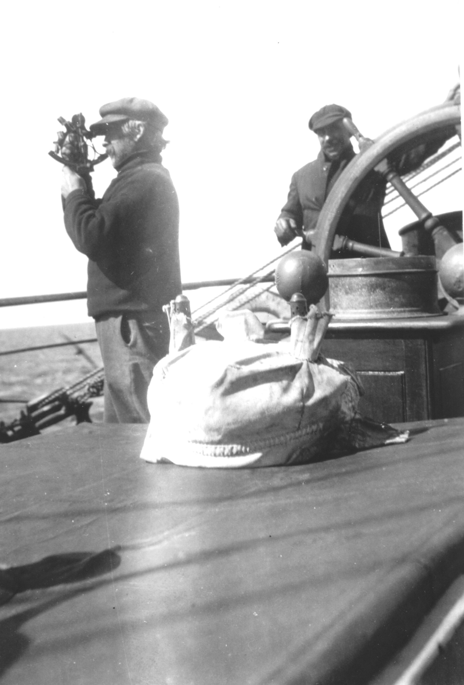 A black and white photo of two men on a boat