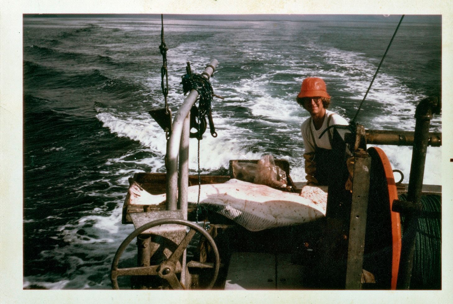 A man in a hard hat is on a boat in the ocean