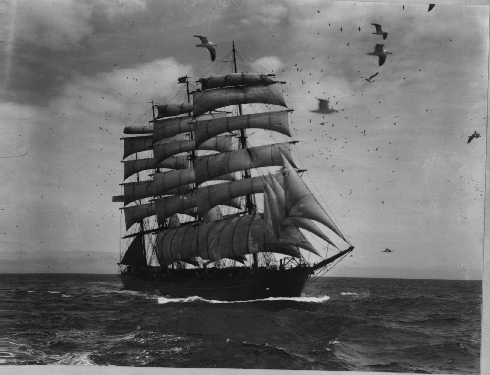 A black and white photo of a sailboat in the ocean