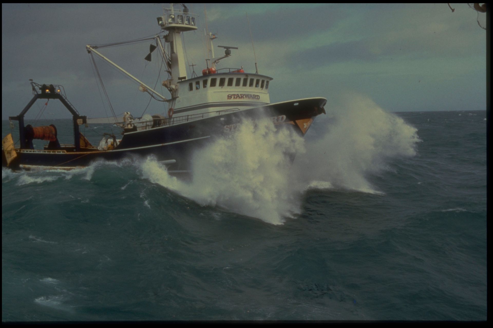A large fishing boat is floating on top of a large body of water.