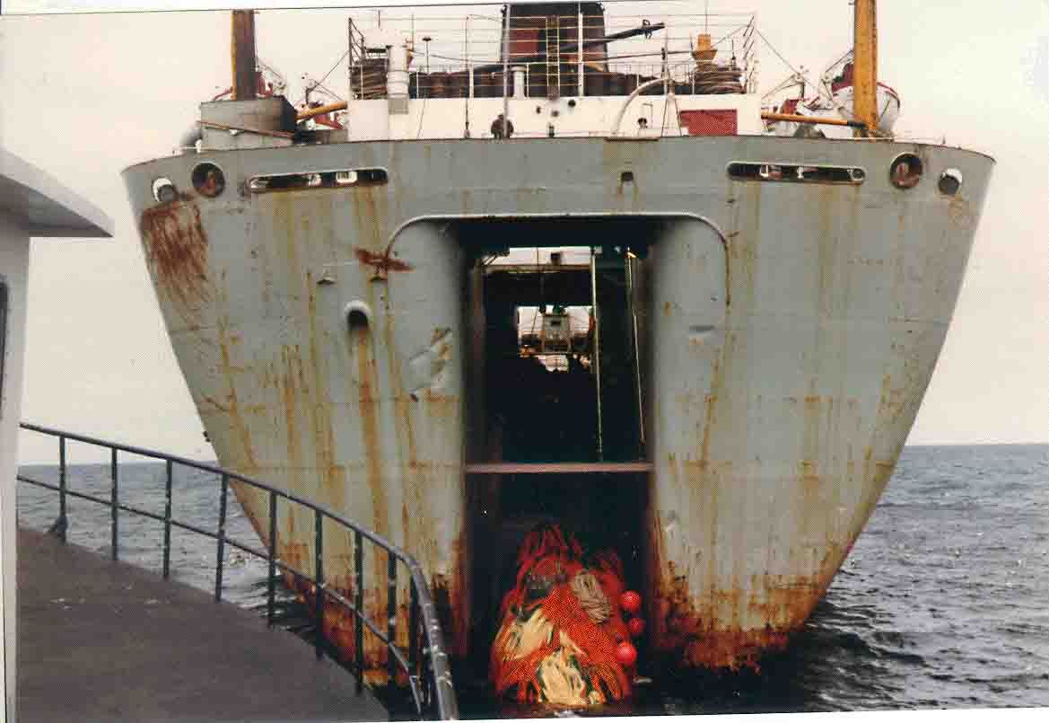 A large ship is floating in the ocean with the door open