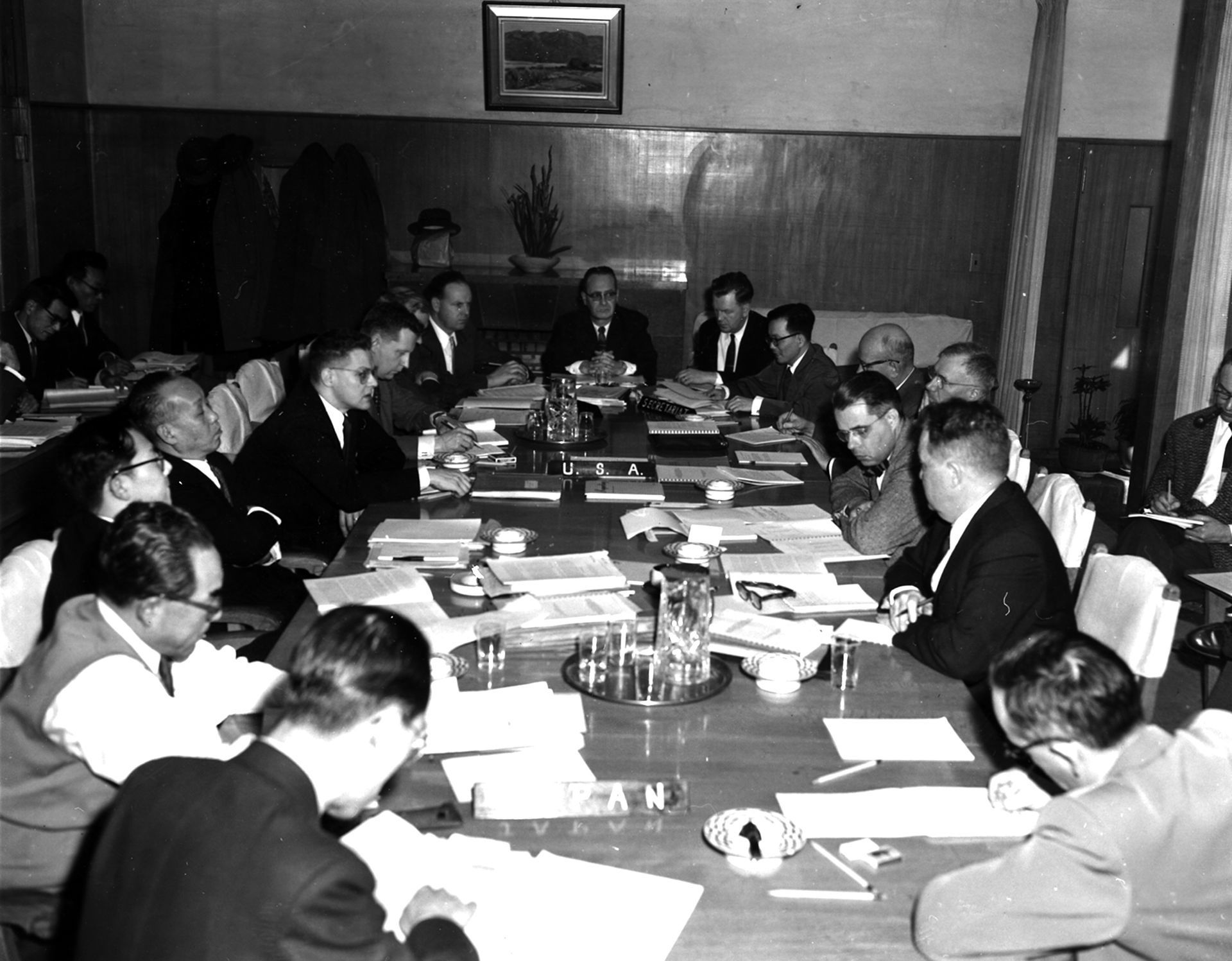 A black and white photo of a group of people sitting around a table
