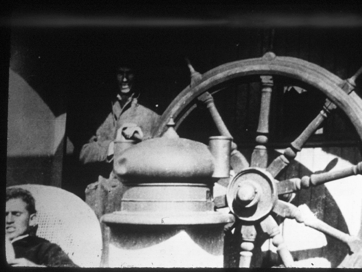 A black and white photo of a man behind a steering wheel