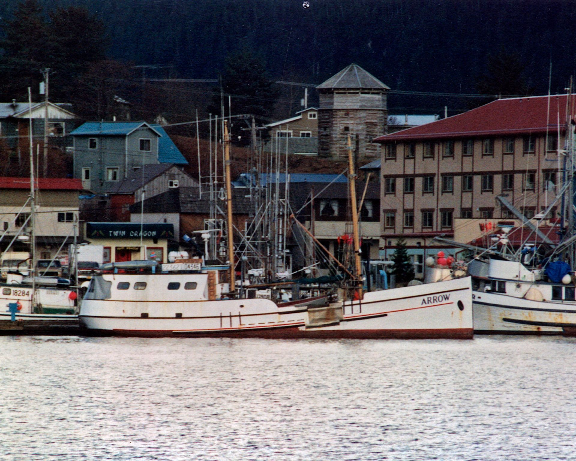 A few boats are docked in a harbor and one of them has the number 11 on it