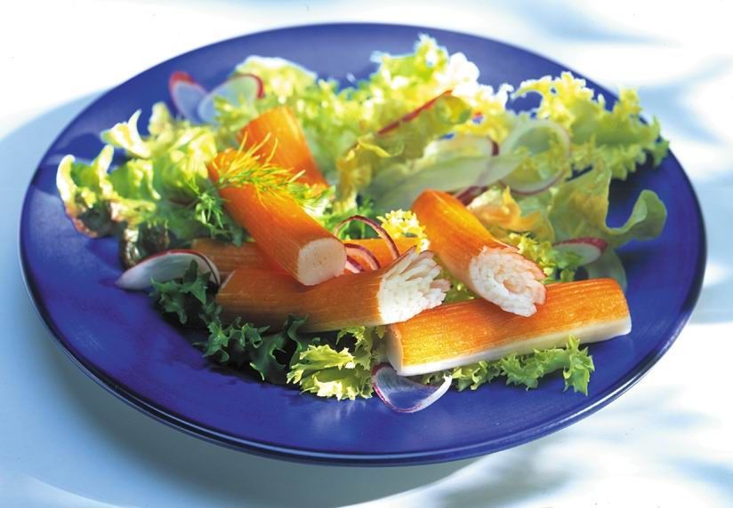 A salad with crab sticks and lettuce on a blue plate