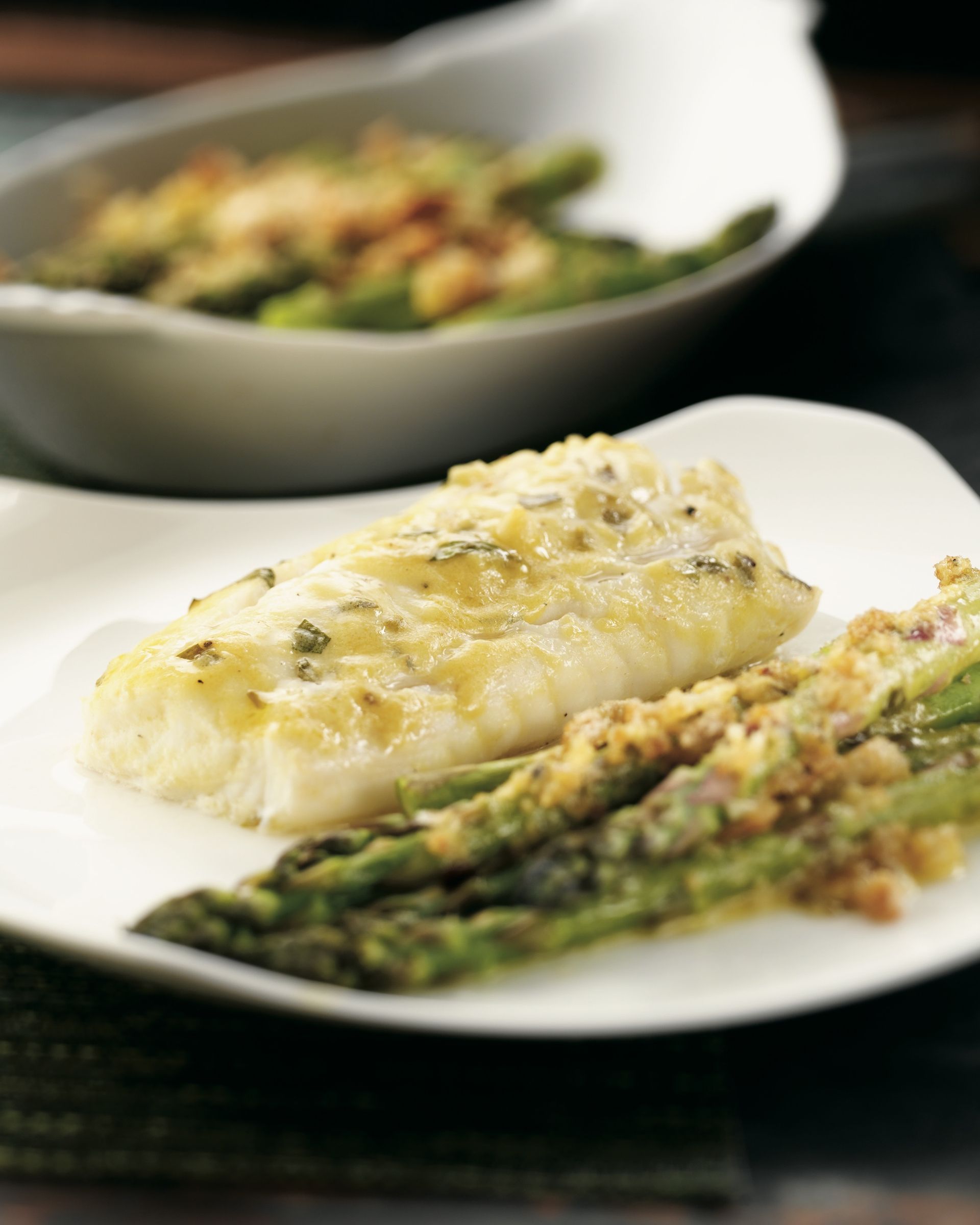 A plate of food with asparagus and fish on it