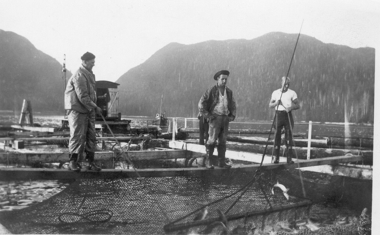 A black and white photo of three men standing on a bridge