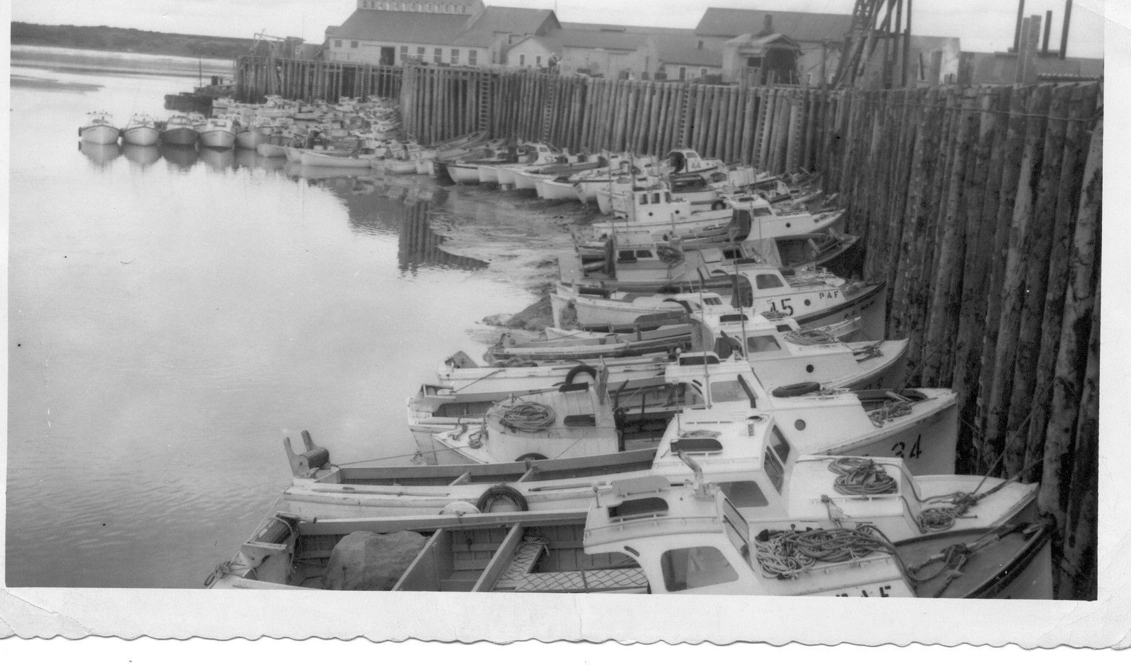 A black and white photo of boats in a harbor
