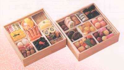 Two wooden boxes filled with different types of food on a table.