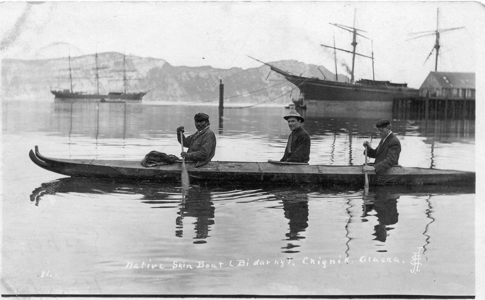 A black and white photo of three men in a boat