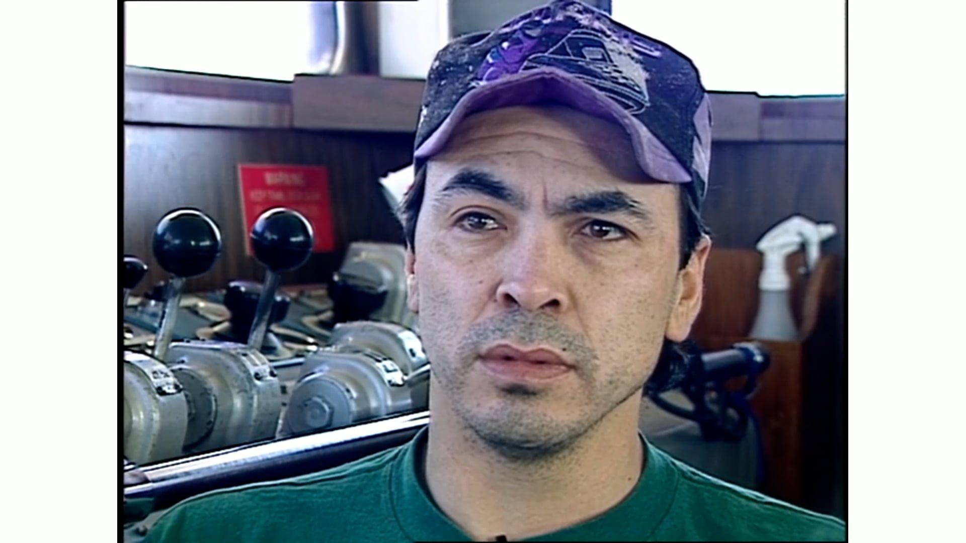 A man wearing a purple hat and a green shirt