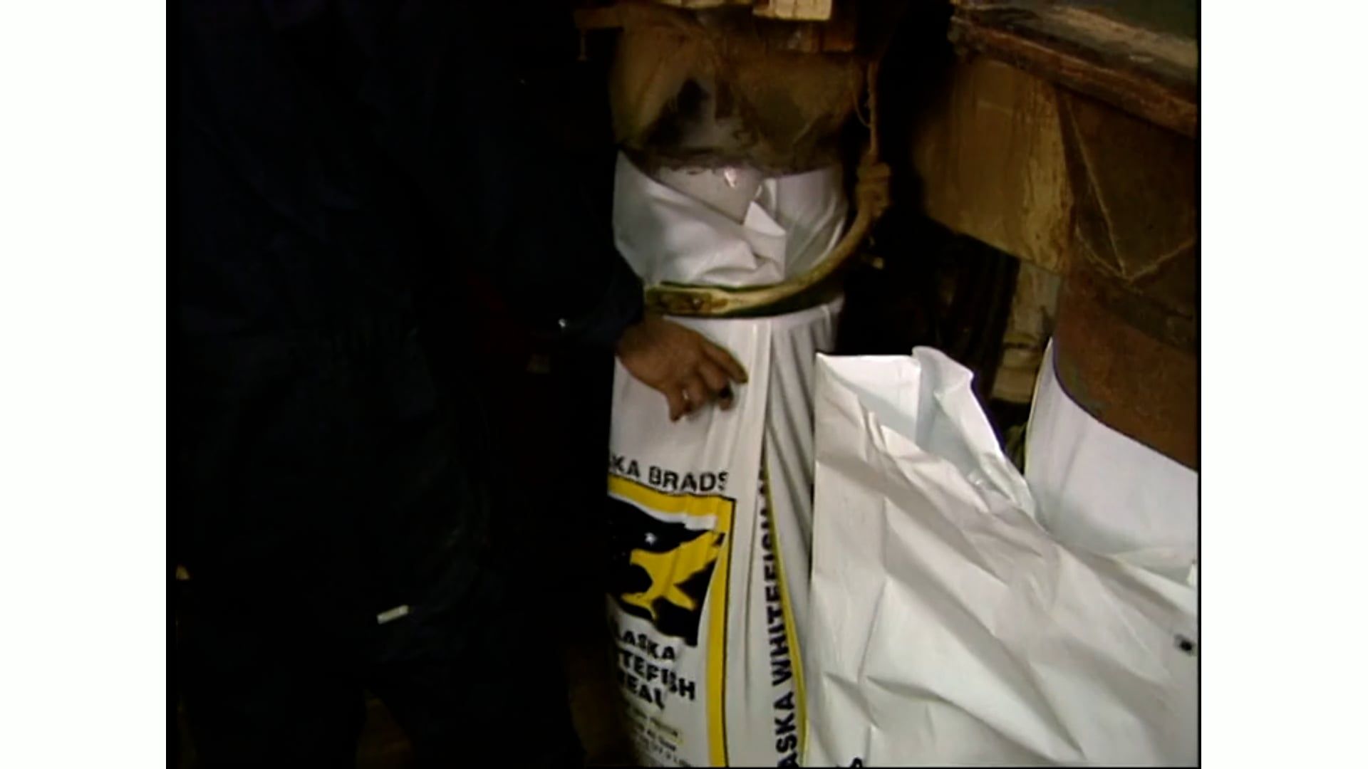 A person is standing next to a bag that says ' aa ' on it