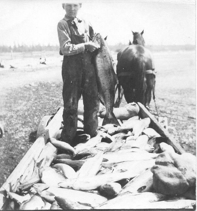 A black and white photo of a man holding a fish