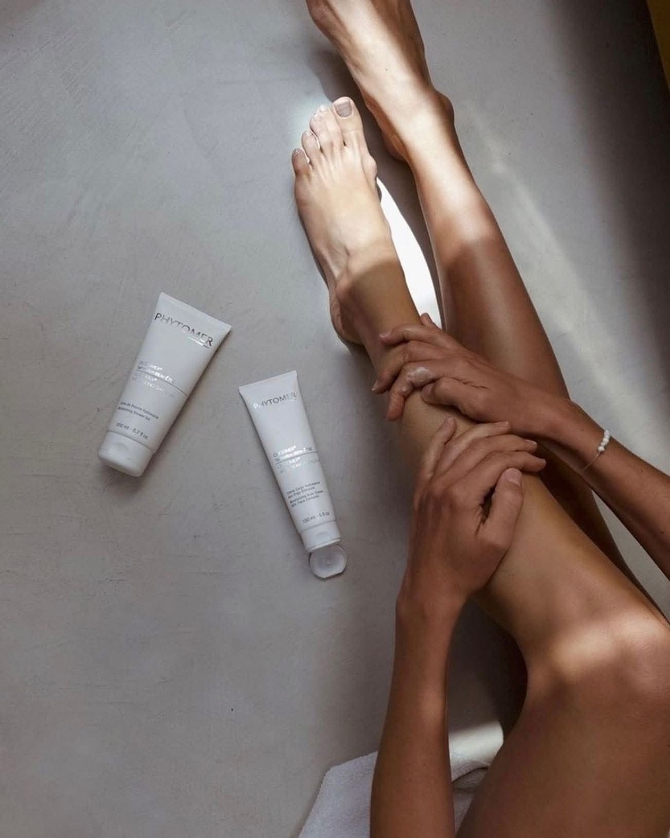 Une femme touche son bras avec ses mains.