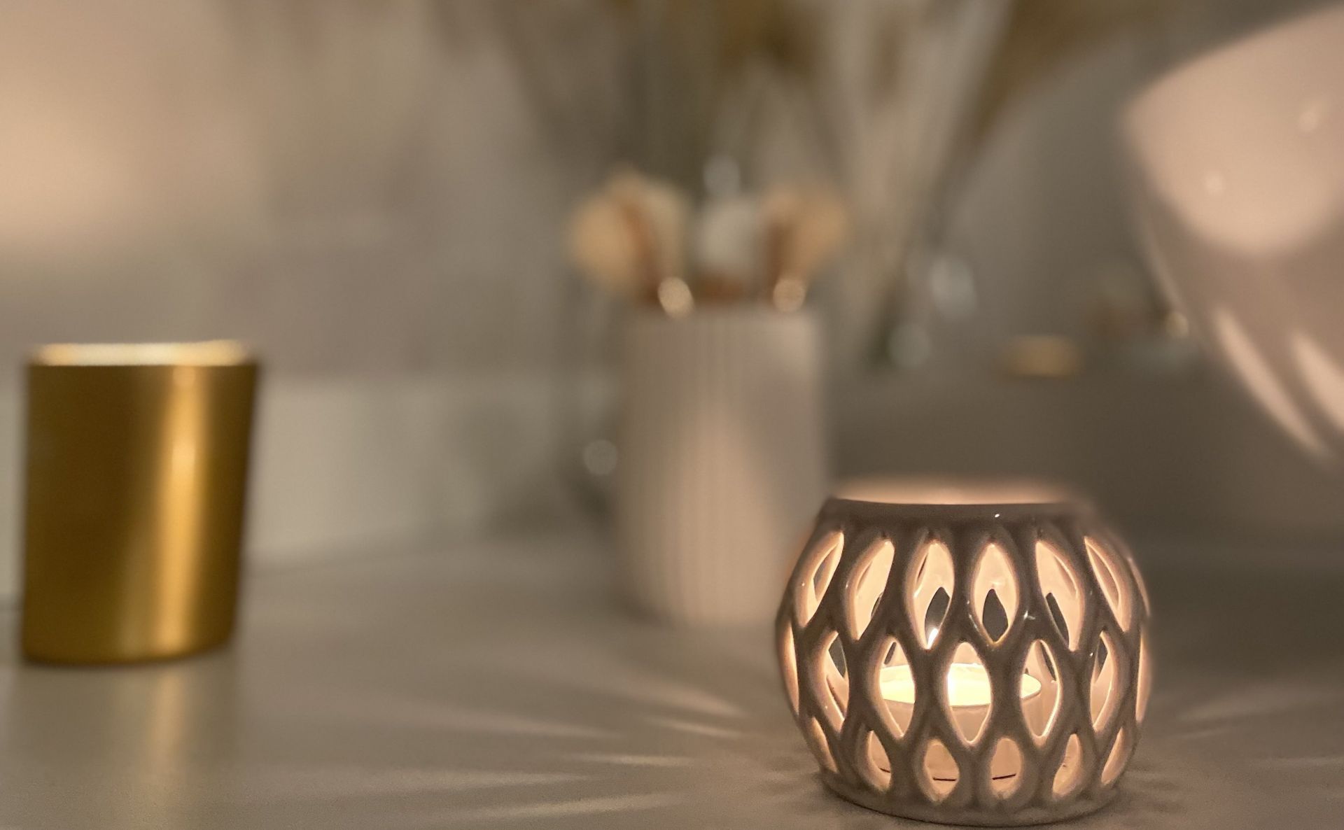 Une bougie est posée sur une table à côté d'une tasse.