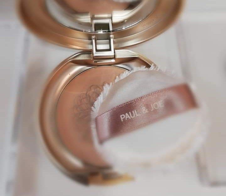 Un gros plan d'une houppette à poudre Paul & Joe