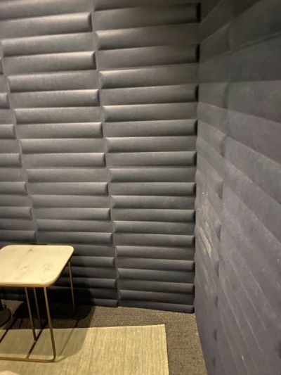 A room with a table and chairs and a gray wall.