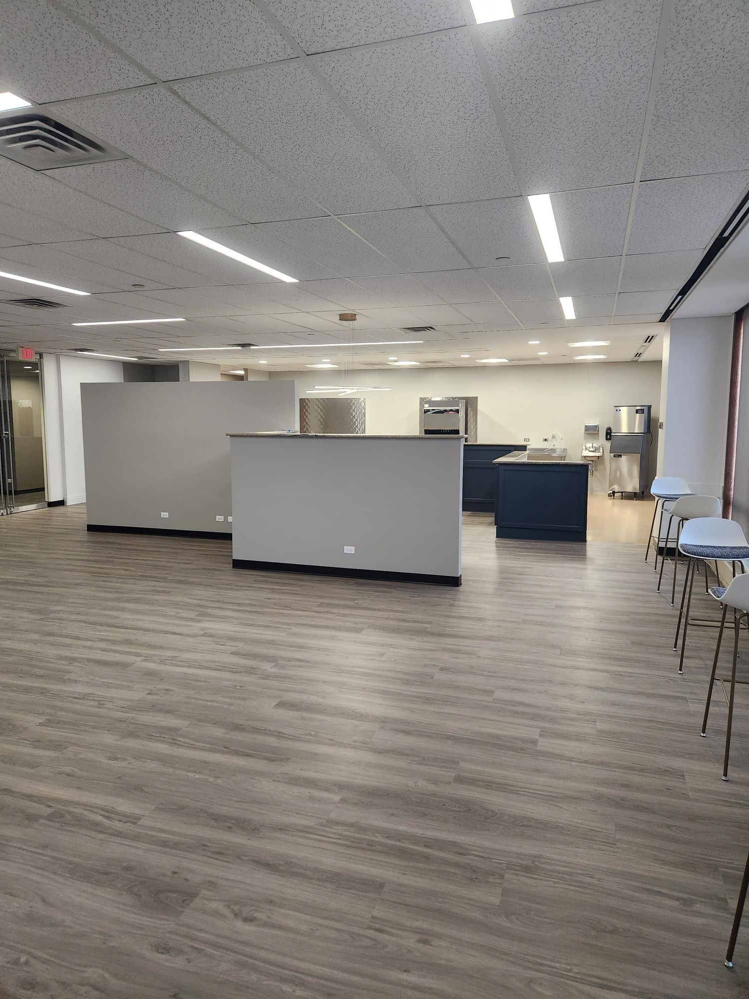 A large empty room with wooden floors and tables.