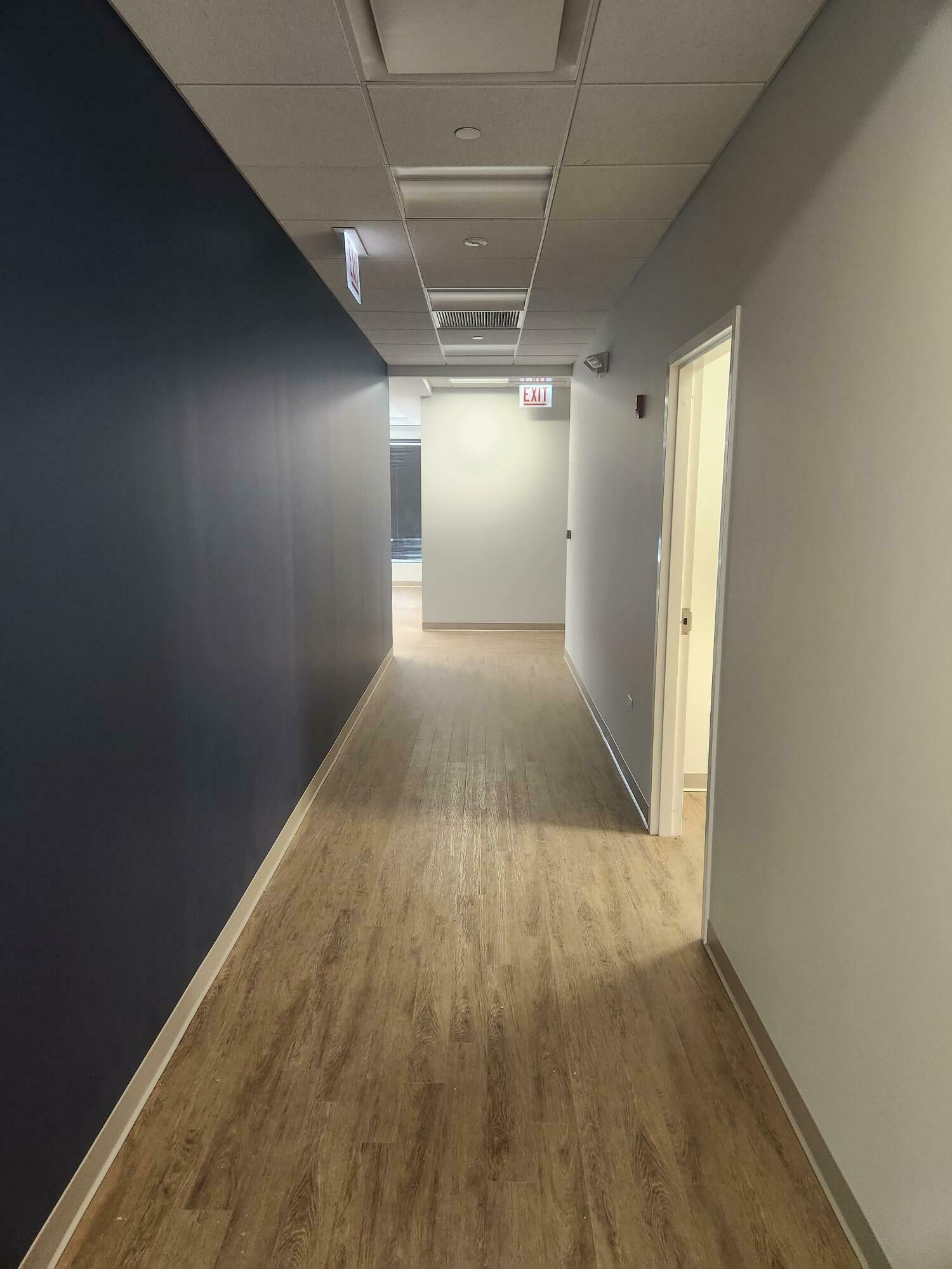 A long hallway with wooden floors and blue walls