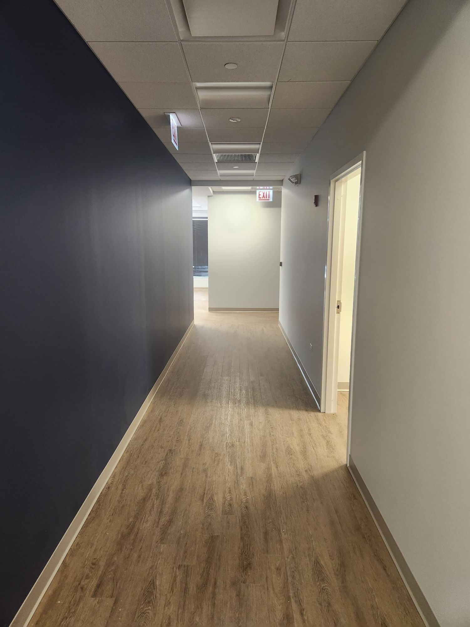 A long hallway with blue walls and wooden floors