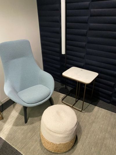 A chair and ottoman are in a room with a table.