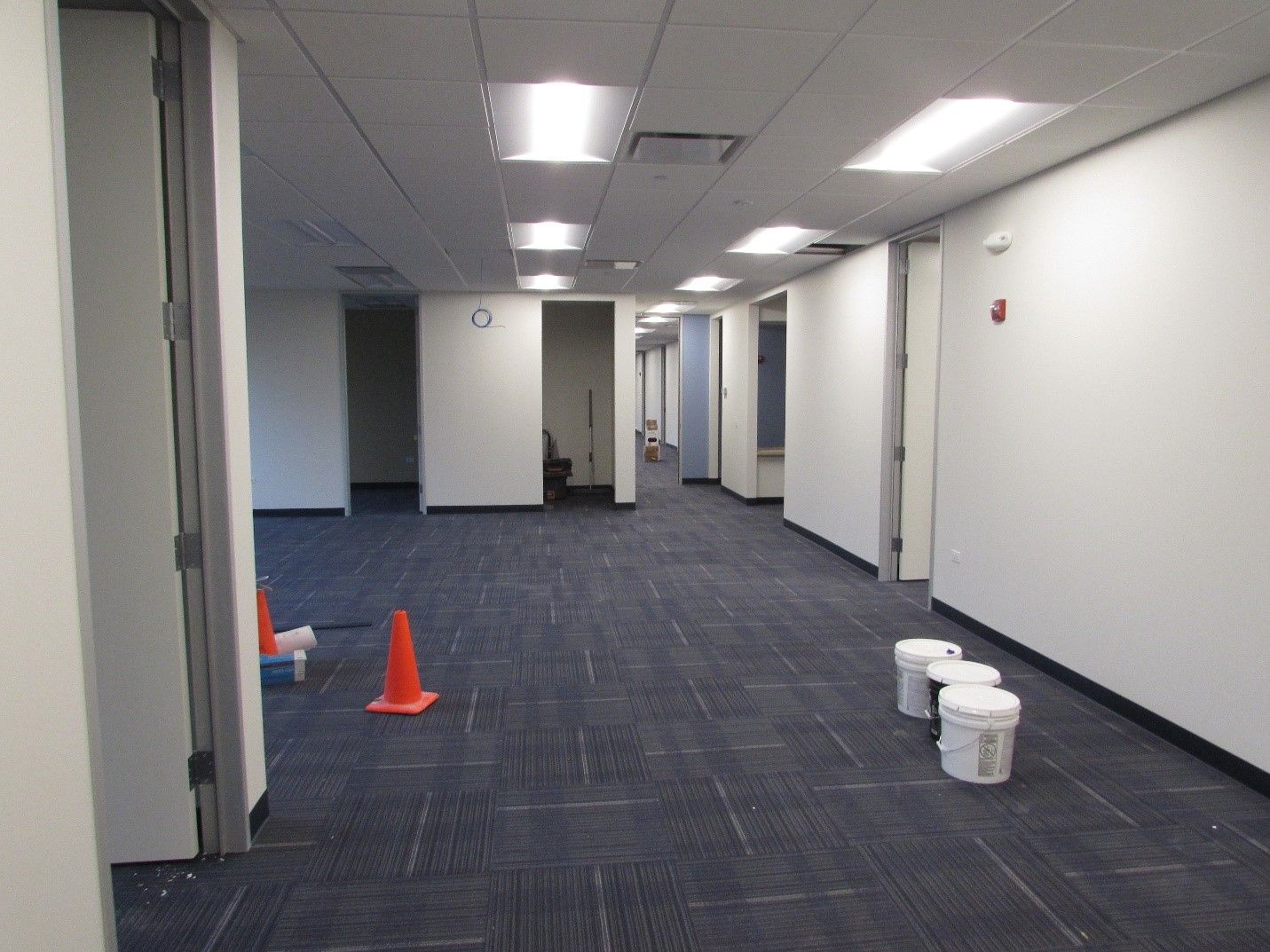 An empty hallway with buckets and cones on the floor