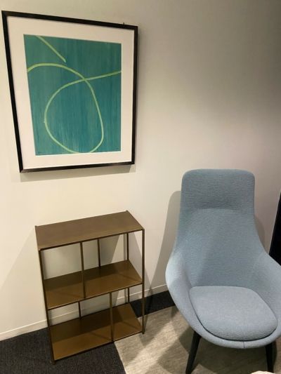 A room with a chair and a picture on the wall