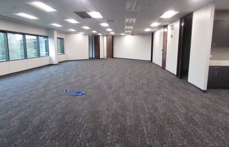 A large empty room with a carpeted floor and white walls.