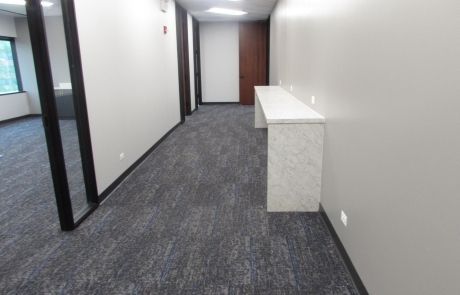 A long hallway with a table in the middle of it.